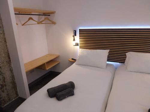 a bedroom with a bed with a black object on it at APARTAMENTO CÉNTRICO - Tetuan - RH Santander 3B in Santander