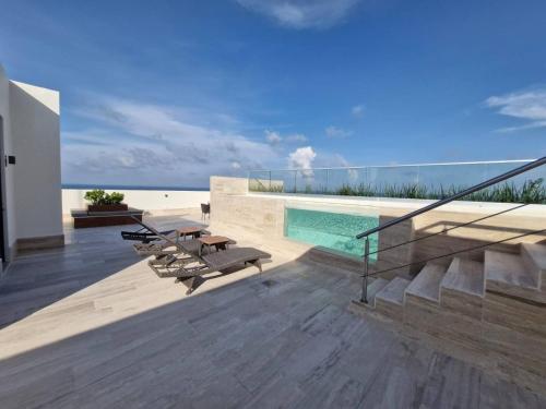 a balcony of a house with a swimming pool at Beatiful Loft in Puerto Morelos Beach Front 9-4 in Puerto Morelos