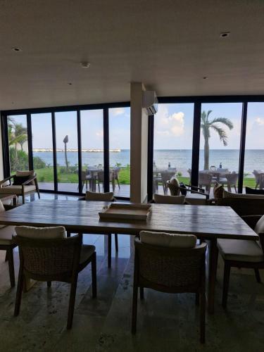 a dining room with tables and chairs and the ocean at Beatiful Loft in Puerto Morelos Beach Front 9-4 in Puerto Morelos