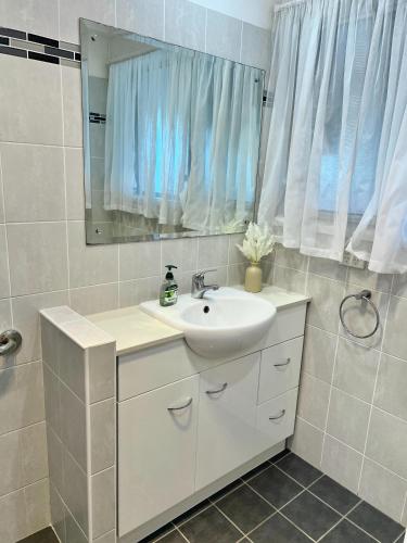 a bathroom with a sink and a mirror at Cosy Room in North Ryde #2 in Sydney