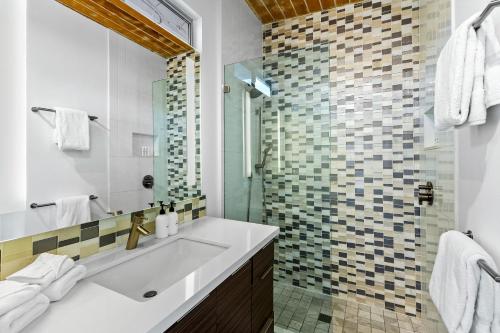 a white bathroom with a sink and a shower at Mid Century Mood House by ACME House Company in Palm Springs