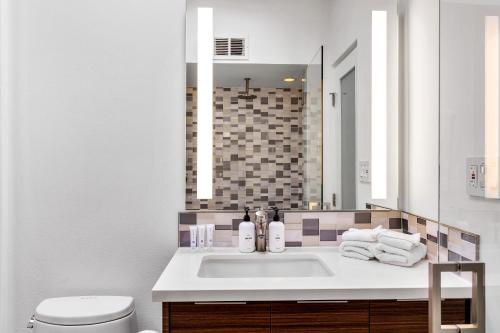 a bathroom with a sink and a toilet and a mirror at Mid Century Mood House by ACME House Company in Palm Springs