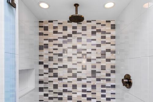 a bathroom with a shower with a checkered tile wall at Mid Century Mood House by ACME House Company in Palm Springs