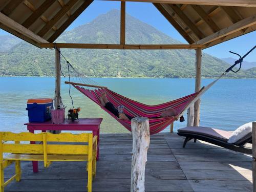 a hammock on a dock with a view of a lake at Luxe A-Frame on Lake Atitlán in Santiago Atitlán