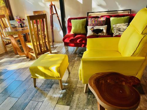 a yellow couch and chairs in a room at Luxe A-Frame on Lake Atitlán in Santiago Atitlán
