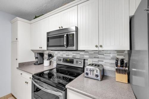 une cuisine avec une cuisinière et un micro-ondes dans l'établissement Hilton Head Haven Coligny Beach 3 Balconies, à Île de Hilton-Head