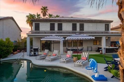 a house with a swimming pool with chairs and umbrellas at Sleeps 16 Pool Hot Tub Sport Court Game Room in Peoria