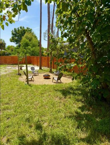 a park with two benches and a fire pit at Zen Container Tiny Home with Fenced-in Yard, Fire Pit, Centrally located and Pet Friendly in Fort Myers