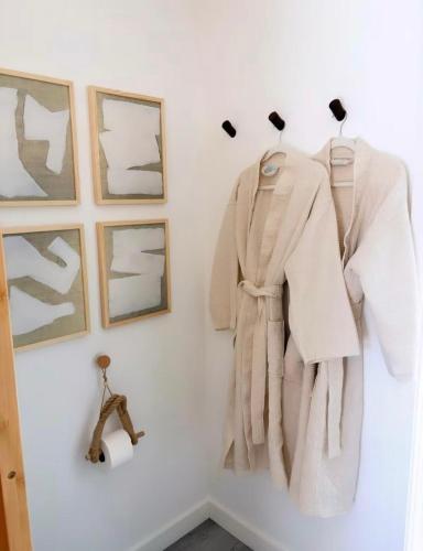 a coat hanging on a wall with pictures at Zen Container Tiny Home with Fenced-in Yard, Fire Pit, Centrally located and Pet Friendly in Fort Myers