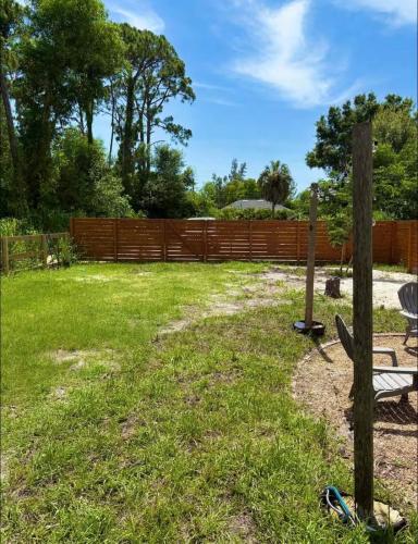 a yard with a fence and a bench at Zen Container Tiny Home with Fenced-in Yard, Fire Pit, Centrally located and Pet Friendly in Fort Myers