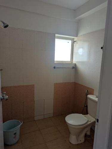 a bathroom with a toilet and a window at Ocean Park Haven Apartments in Kannur