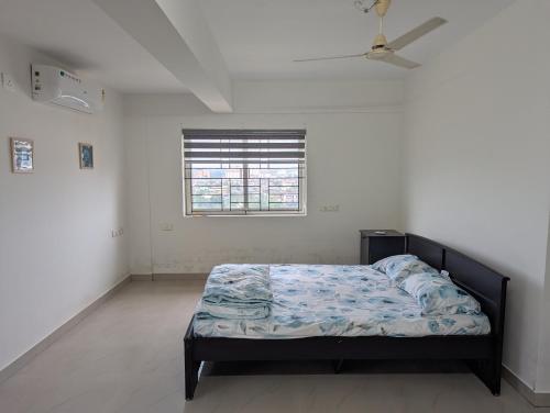 a bedroom with a bed in a room with a window at Ocean Park Haven Apartments in Kannur