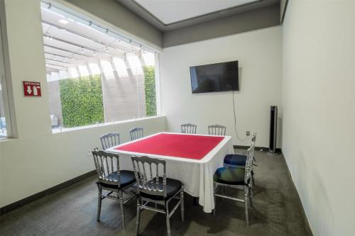 a dining room with a red table and chairs at Best Western Plus Santa Cecilia Pachuca in Pachuca de Soto