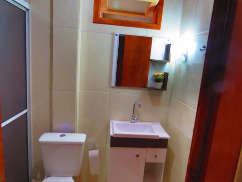 a bathroom with a white toilet and a sink at Pousada Angela in Urubici