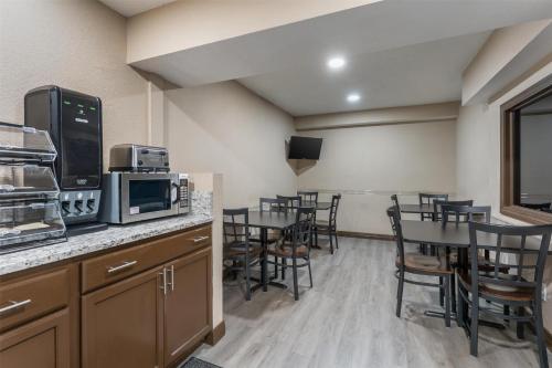 a kitchen with a dining room with tables and chairs at SureStay Hotel by Best Western Summersville in Summersville