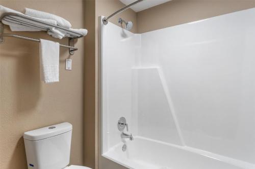 a bathroom with a white toilet and a shower at SureStay Hotel by Best Western Summersville in Summersville