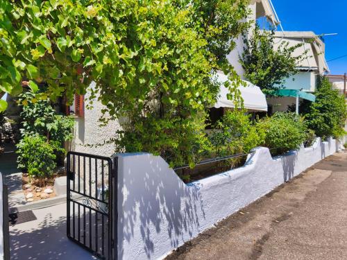 a fence with plants on the side of a street at Akrata Golden Beach House 2 in Aíyira