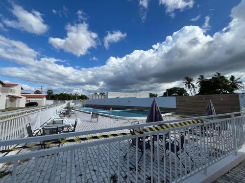 a swimming pool with chairs and umbrellas on a balcony at Casa de aluguel por temporada in Parnaíba