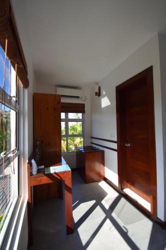 a kitchen with a wooden desk and a window at Antares Dhangethi & Spa in Dhangethi