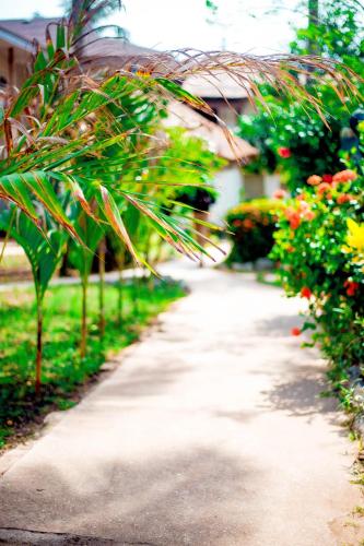 a path in a garden with flowers and plants at Oasis beach resort in Cape Coast
