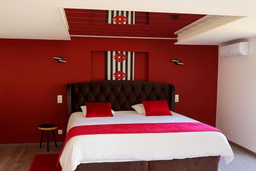 a red bedroom with a large bed with red walls at Le Refuge - Studio haut de gamme in Masevaux