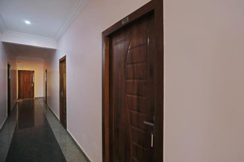a hallway with a wooden door in a building at Hotel O HOTEL UTSAV PALACE in Bengaluru