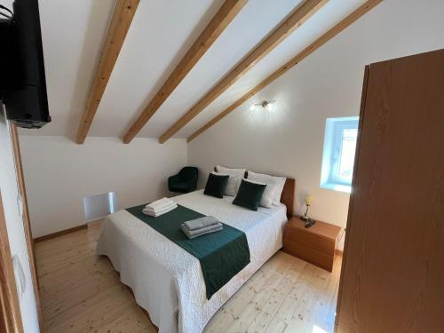 a bedroom with a bed and a flat screen tv at Quinta do Carvalho Cerquinho in Louriceiras de Baixo