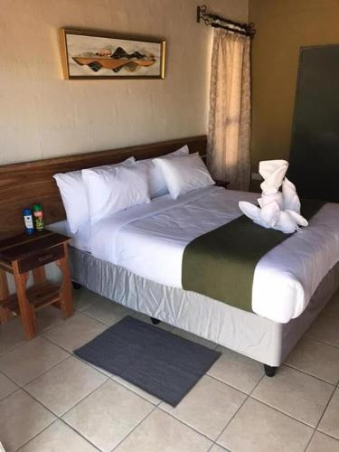 a bedroom with a large bed with white pillows at African Excursions Guest lodge in Khwai
