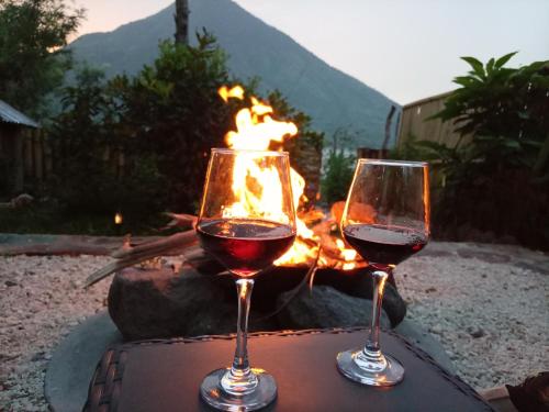 two glasses of red wine next to a fire pit at Luxe A-Frame on Lake Atitlán in Santiago Atitlán
