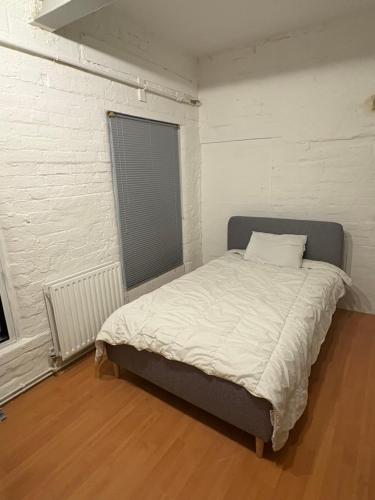 ein Bett in einem Zimmer mit einer weißen Wand in der Unterkunft 3 Bed Luxury Contractors Apartment, Free Parking, City Centre, Fast WiFi by Opulent Stays in Derby