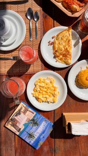 a table with plates of food and a slice of pizza at Kamaiurá Pousada in Caraíva
