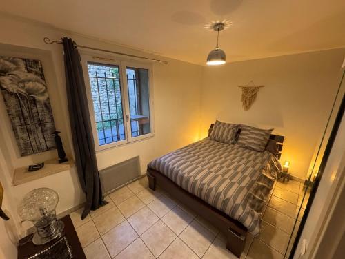 ein Schlafzimmer mit einem Bett und einem Fenster in der Unterkunft Maison de charme, pleine nature in Saint-Côme-et-Maruéjols