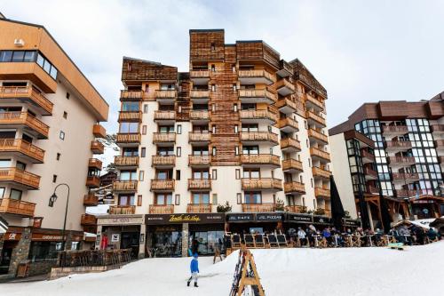 a large building with people skiing in the snow at Résidence Zenith - SKIS AUX PIEDS POUR CE STUDIO 3 PERSONNES MAE-7753 in Val Thorens
