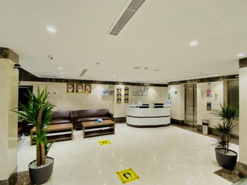 a lobby with a couch and some plants in it at Itlalat uhud hotel - فندق إطلالة احد in Al Madinah