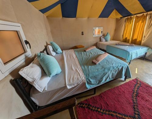 a bedroom with two beds in a tent at Luxury Desert Camp Merzouga with Air Conditioning and Heating in Merdani
