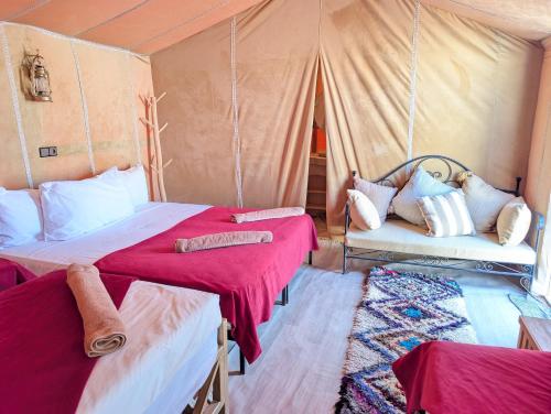 a room with two beds in a tent at Luxury Desert Camp Merzouga with Air Conditioning and Heating in Merdani