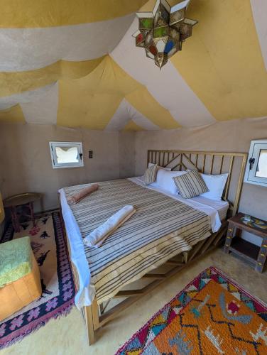 a bedroom with a large bed in a tent at Luxury Desert Camp Merzouga with Air Conditioning and Heating in Merdani