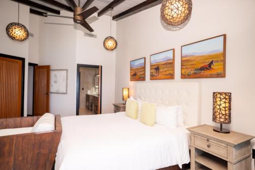 a bedroom with a large white bed and two lights at Tamarind Hills Resort & Villas in Johnsons Point