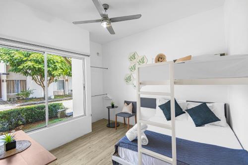 a bedroom with a bunk bed and a window at Jacó Condo 3 BR, Pool & families in Jacó