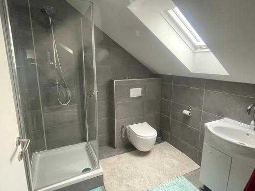 a bathroom with a shower and a toilet and a sink at Zentral gelegenes wohnhaus in Oedt
