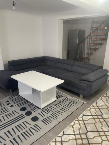 a living room with a blue couch and a white table at Zentral gelegenes wohnhaus in Oedt