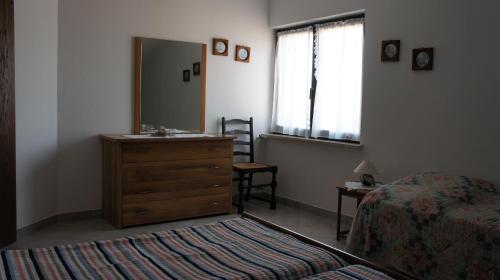 a bedroom with a dresser and a mirror and a bed at Suran Apartments in Pula