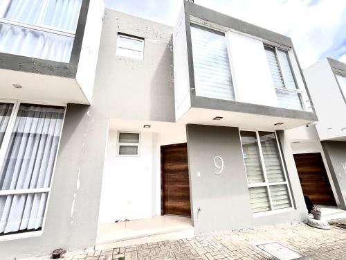 a white house with a front door at Casa Equipada Portal Bellavista Riobamba in Riobamba
