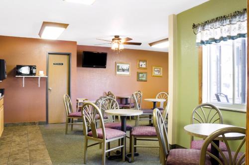 a dining room with tables and chairs and a tv at Econo Lodge, Downtown Custer Near Custer State Park and Mt Rushmore in Custer