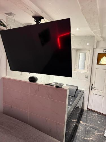 a large flat screen tv on a wall in a room at Secret intime in Chalon-sur-Saône