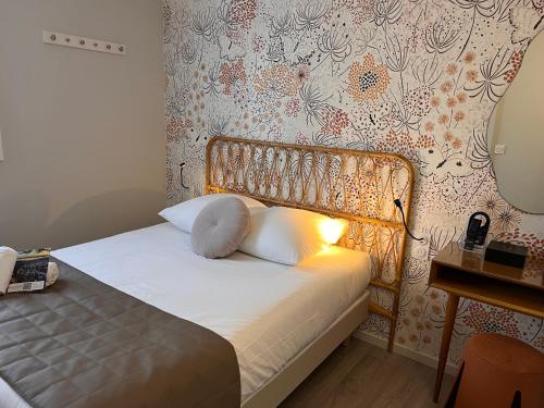 Una cama o camas en una habitación de Hotel Arc-En-Ciel Colmar Contact Hotel