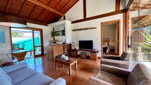 a living room with a couch and a tv at Chalet Monte Boa Vista - Aconchego na Serra com Hidromassagem Exclusiva in Teresópolis