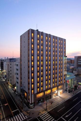 a tall building with lights on in a city at Shizutetsu Hotel Prezio Shizuoka Ekinan in Shizuoka