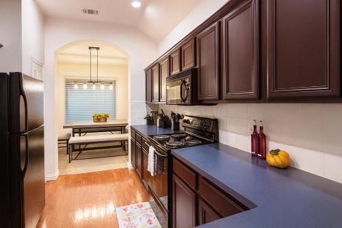 a kitchen with dark brown cabinets and a counter top at Entire Home 3BR Hidden Gem Getaway with Level 2 EV Charger, Central Location in McKinney