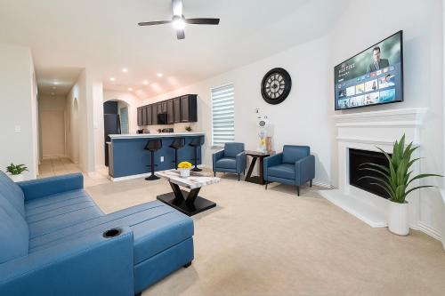 a living room with a blue couch and a fireplace at Entire Home 3BR Hidden Gem Getaway with Level 2 EV Charger, Central Location in McKinney